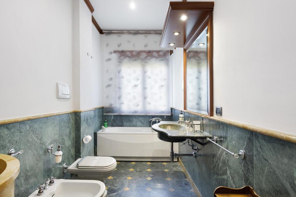 Bagno in marmo verde con vasca e finestra