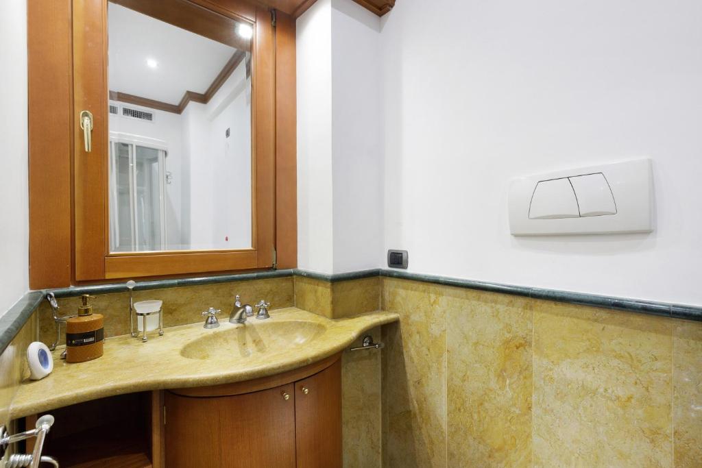 Bagno in marmo con lavabo e ampio specchio