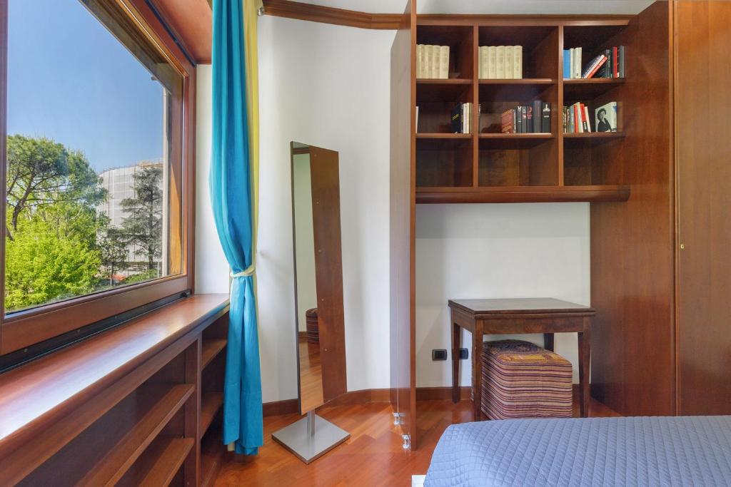 Camera con libreria in legno, specchiera e scrittoio