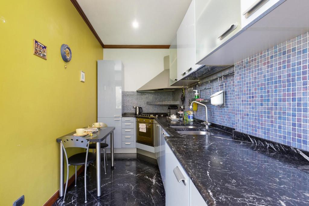 Cucina con piano in marmo e rivestimento a mosaico