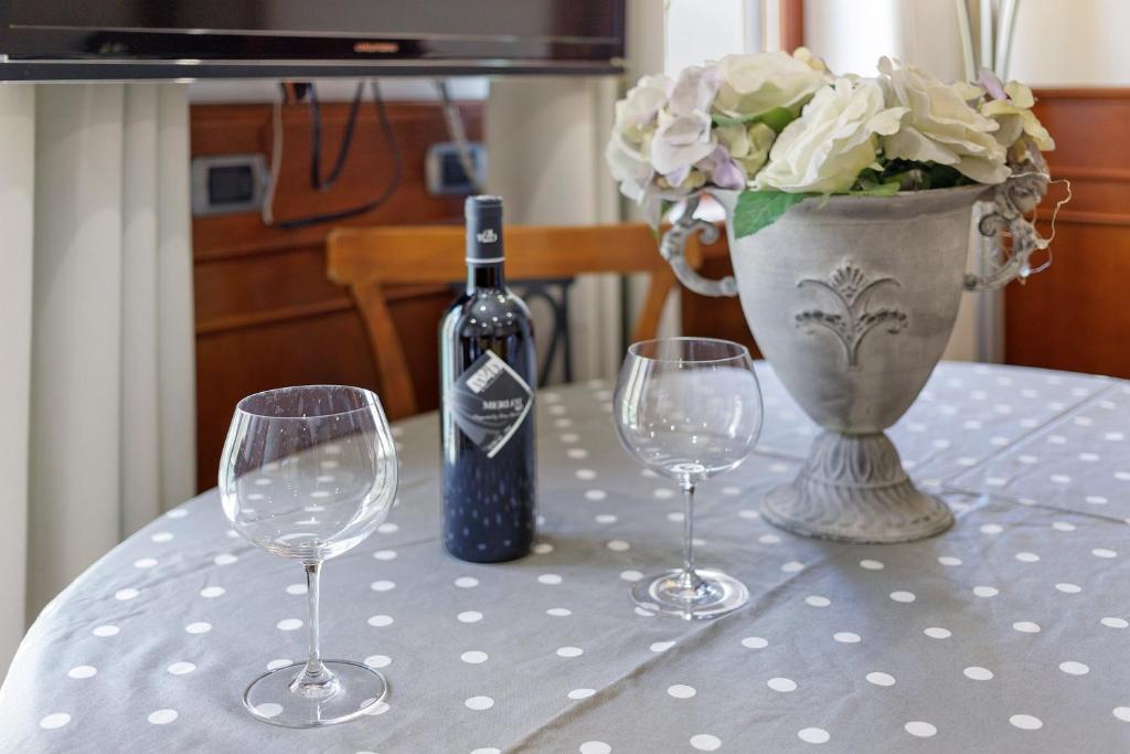 Dettaglio del tavolo con vino e composizione floreale