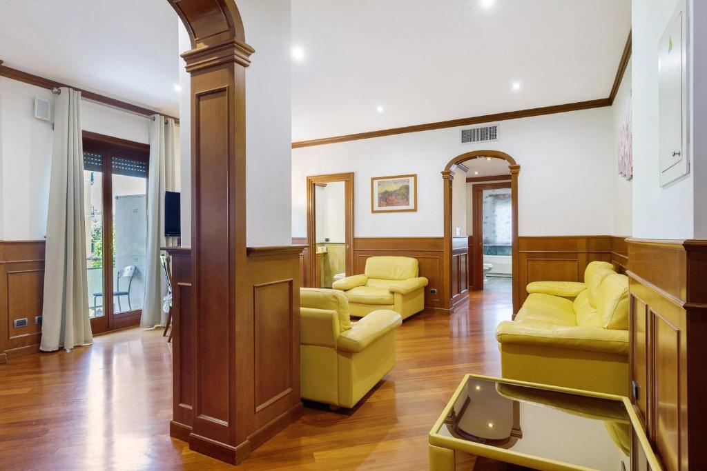 Ampio soggiorno con archi in legno, divani in pelle e affaccio sul balcone