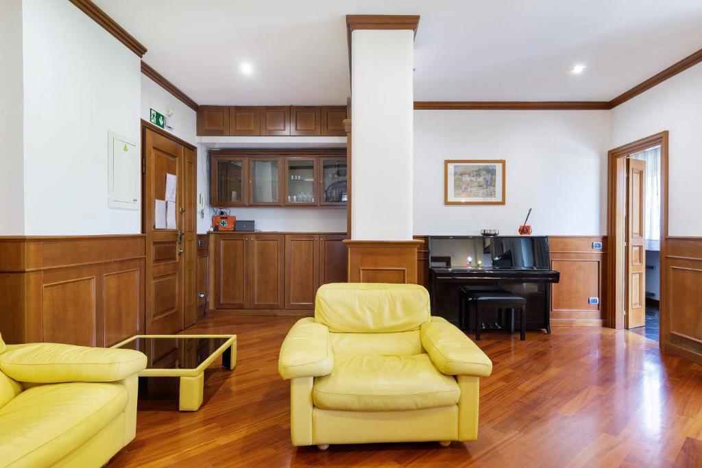 Soggiorno con poltrone in pelle, pianoforte e tavolino in vetro