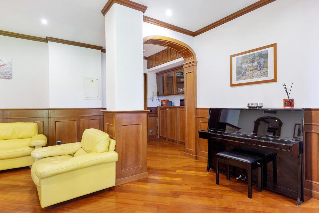 Salotto con pianoforte, poltrone e stampa alle pareti
